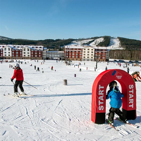 Barn som åker i utstakad bana i skibacke på Romme Alpin Ski Lodge hotell och restaurang. 