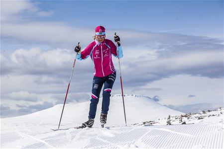 Cross-country skier classic style with mountain in the background
