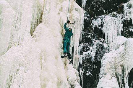 A person is on his way up an ice wall.