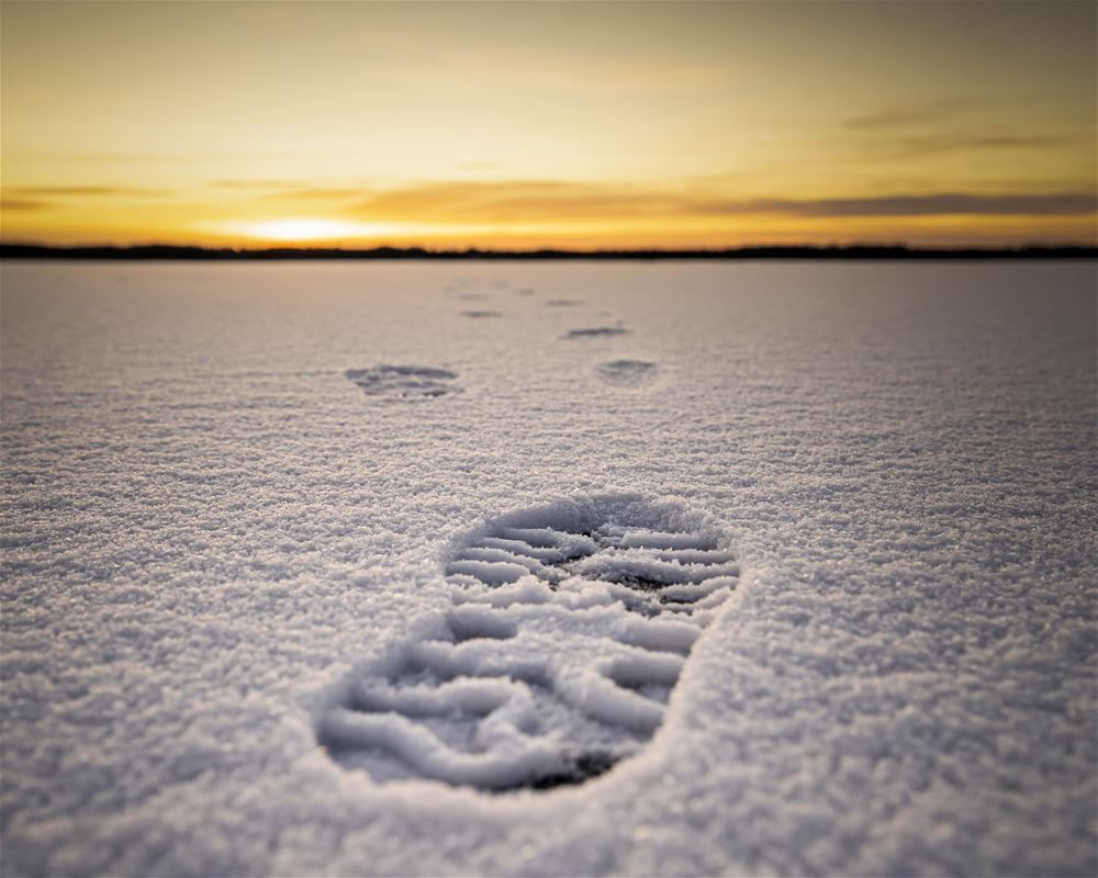 Fotspår på isen i snö.