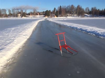 En röd spark på plogad skridskobana. 