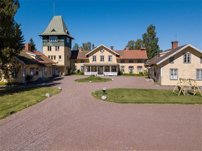Exteriörbild med grusplan framför på Ulfshyttans Herrgård.