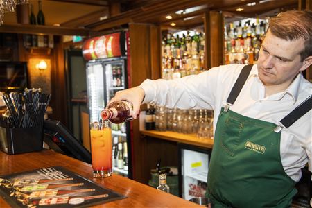 Personal i baren som häller upp en drink. 