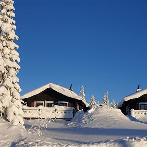Three cottages in winter season and a blue sky.