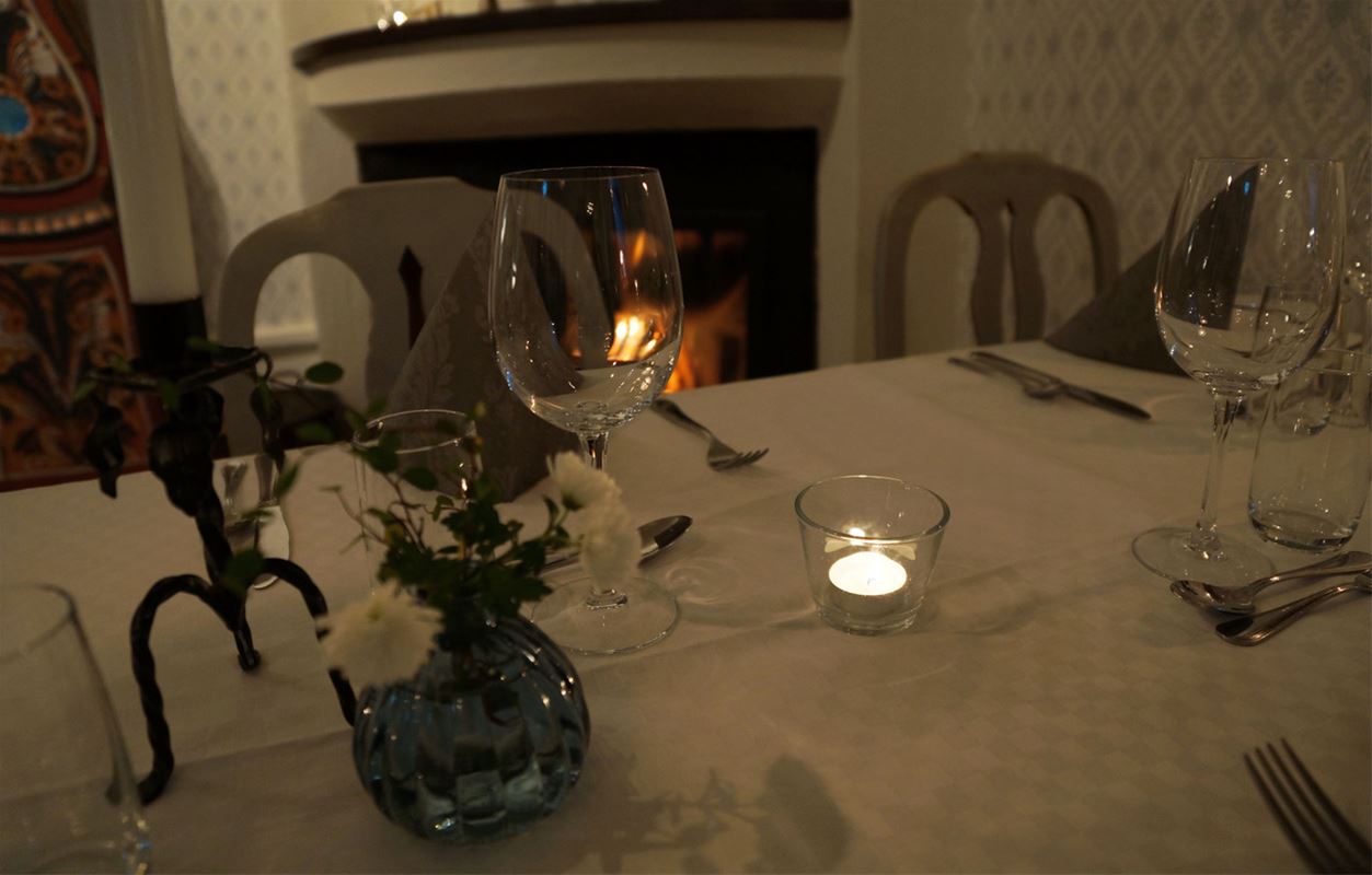Table with candlestick flowers and glass.