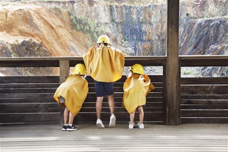 Barn i gula hjälmar och caper tittar ner i Stora stöten.