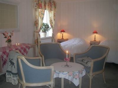 Ett hotellrum inrett med antika stolar och spegel.