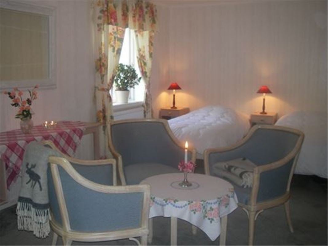 Ett hotellrum inrett med antika stolar och spegel.