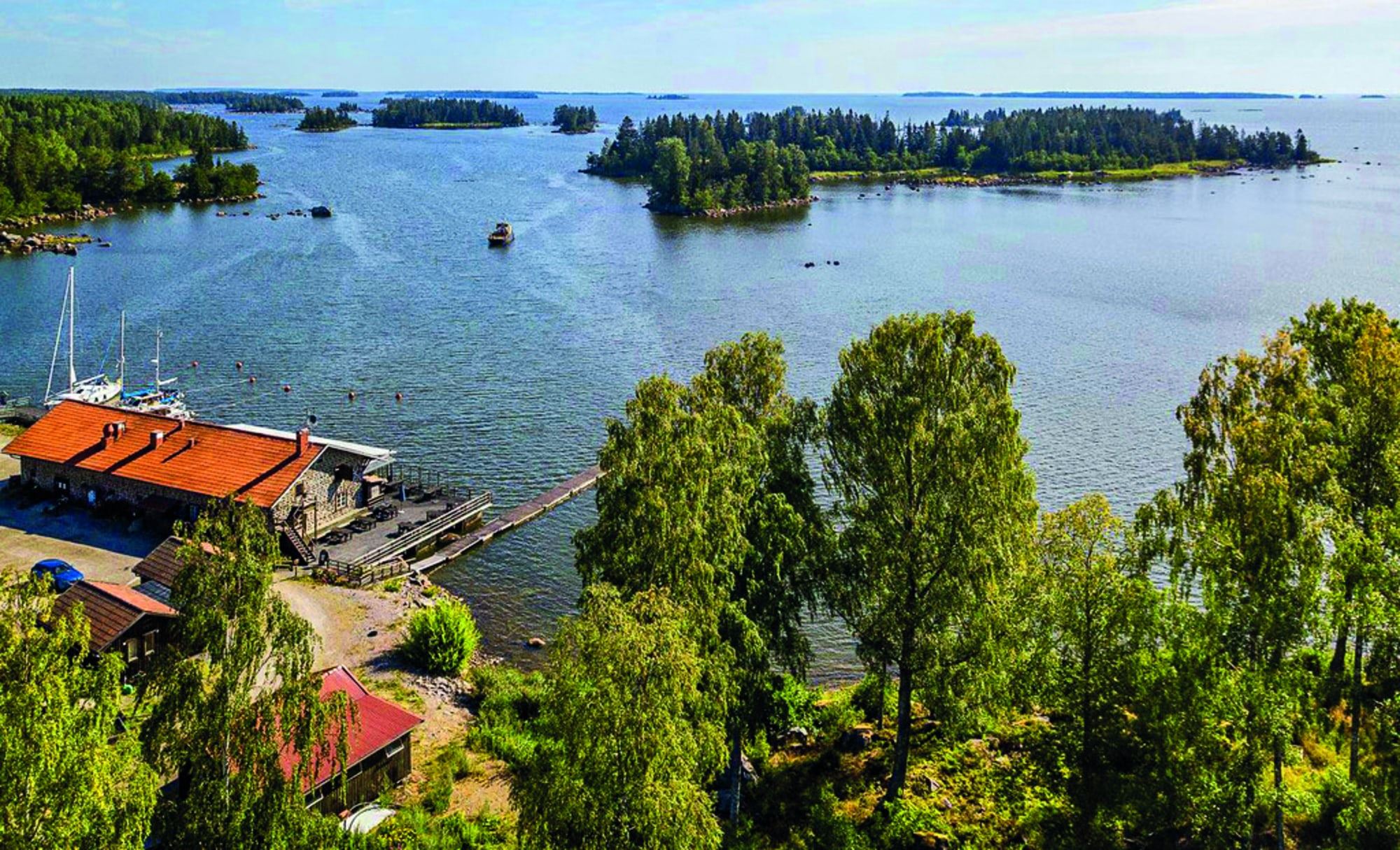 Kustbandet med restaurang i förgrunden en fin sommardag