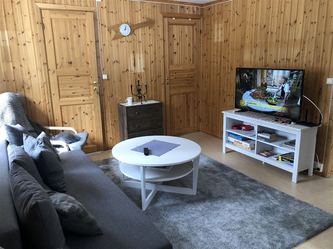 Vardagsrum med soffa och TV i Lillstugan.