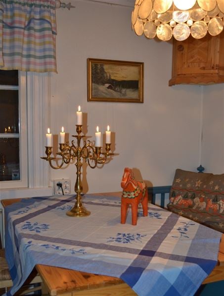 A candlestick and a dala horse on a kitchen table. 
