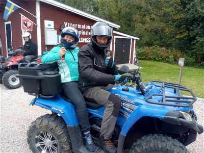 A quad bike with a driver and a passenger. 