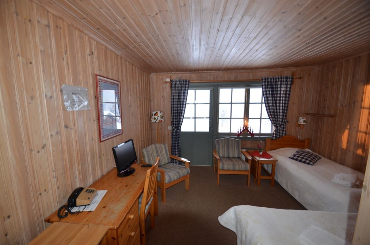 Two single beds placed in an angle to each other and a desk in pine.