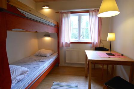 Tvåbäddsrum med en våningssäng och ett fönster. 