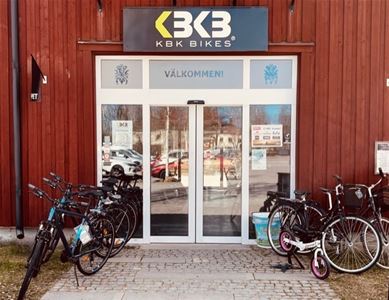 Entre med skylt KBK Bikes, cyklar uppställda utanför entrén.