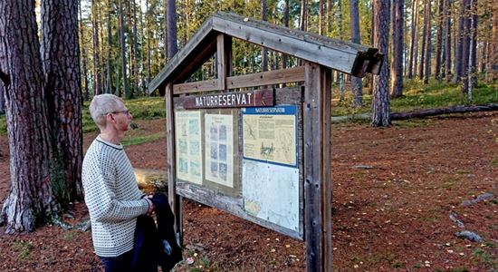 Man tittar på skylt över naturreservatet.