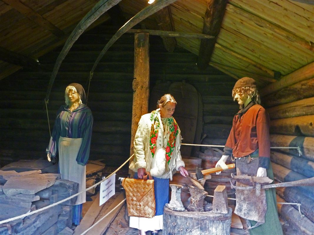 Interior old barn with two mannequins and woman looking at them.