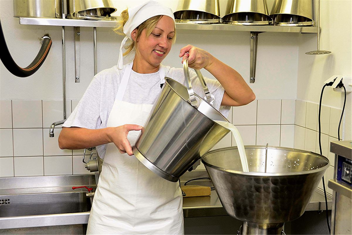 Tin pours milk into large bowl.