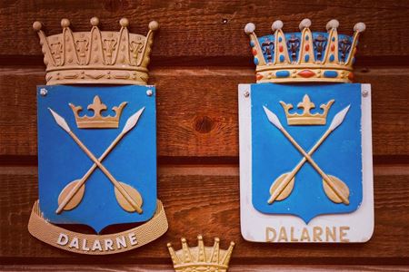 Dalarna landscape weapon with two golden arrows in a cross with blue background.