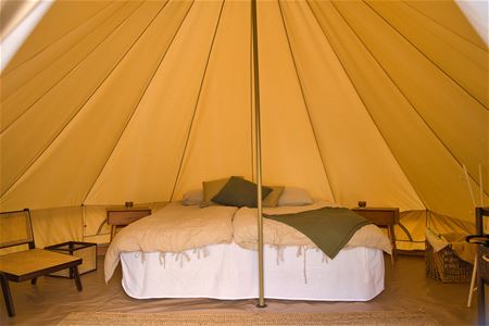 A double bed inside the glamping tent.