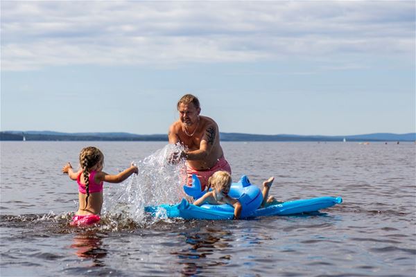 Familj som leker i sjön Siljan vid Siljanbadets Camping. 