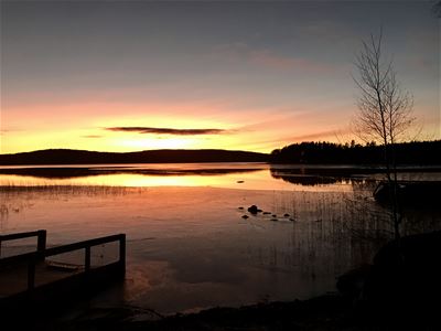 Isbelagd sjö i solnedgång. 