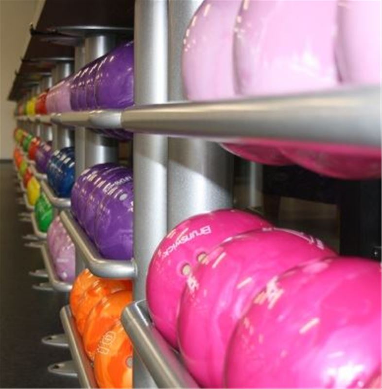 Bowlingklot i olika gälla färger på ställning.