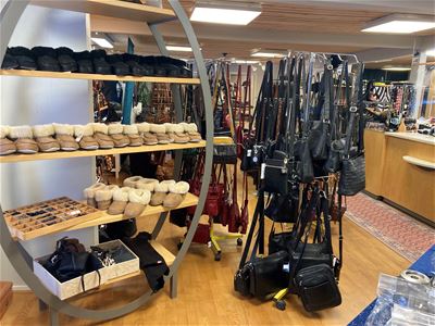 Leather bags and shelf with slippers in the store.