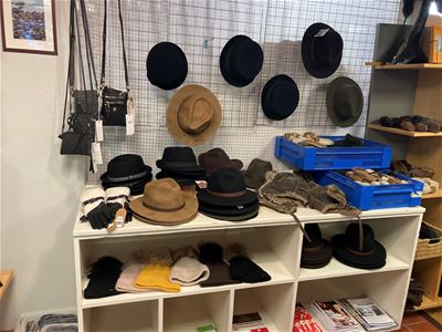 Hats, caps and bags on a shelf and on the wall.