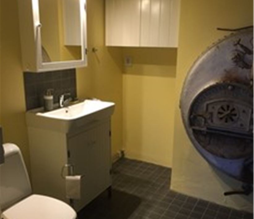 Badrum med toalett och duschkabin