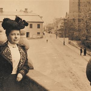 Svartvitt fotografi föreställande Selma Lagerlöf med rådhuset i bakgrunden.
