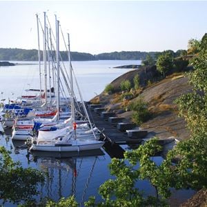  © Tjärö, klippor och hav med båtar vid bryggan
