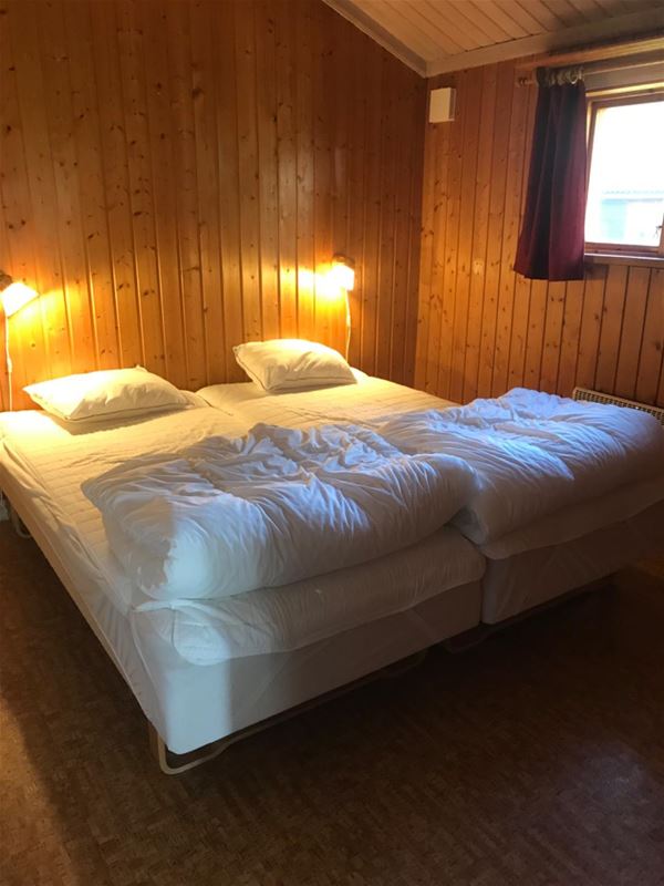 Double bed in a room with pine walls. 