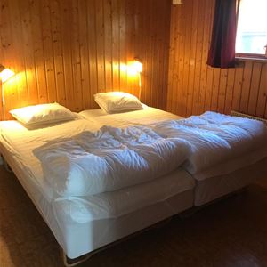 Double bed in a room with pine walls. 