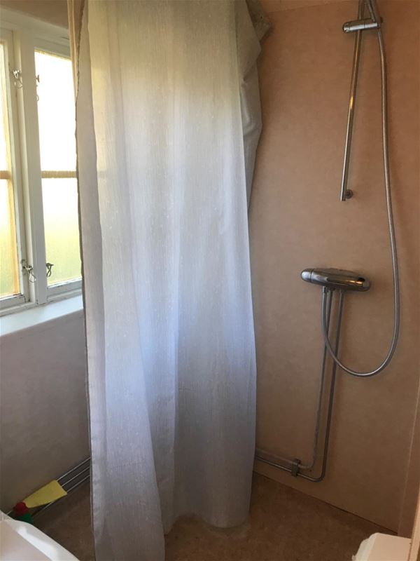 Shower with white shower curtain. 