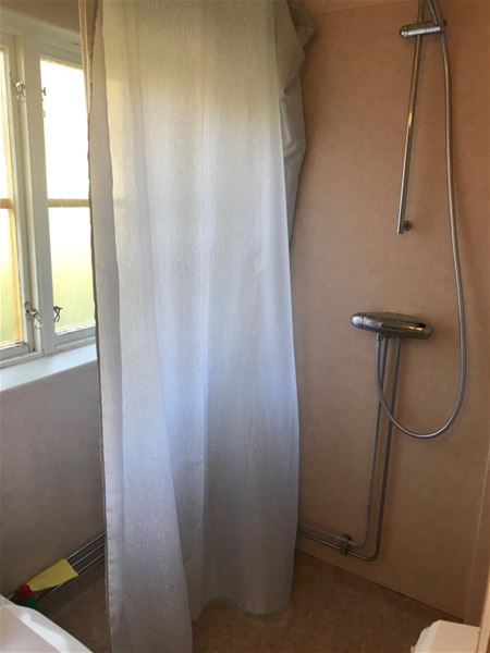 Dusch med vitt duschdraperi. 