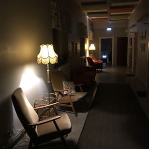 Två fåtöljer i ett mörkt rum som lyses upp av en golvlampa.