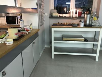 Sideboard in the kitchen with lihted candles and a coffe thermos. 