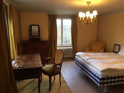 A room with double bed and a writing desk.