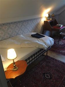 Room with a single bed and a writing desk.