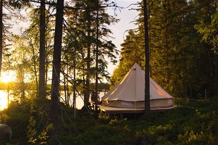 Altan med ett glamping tält i solnedgång.