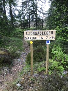 Vandringstig i skogen med en skylt med hänvisning för Ljungåsleden. 
