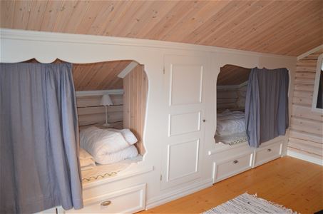 Vitmålade inbyggda sängar med snickarglädje.