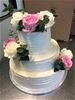 Vit bröllopstårta i tre våningar med rosor