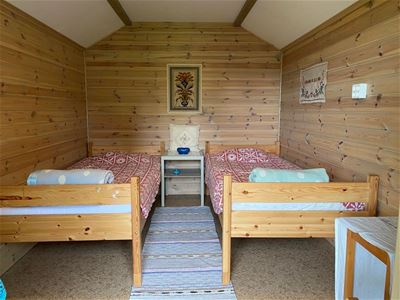 Two single beds inside the small cottage. 