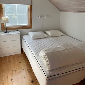 Ett sovrum med en dubbelsäng som är 140 cm.