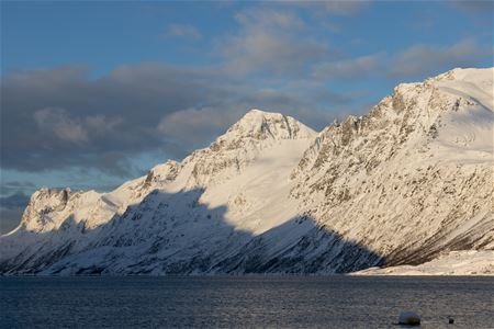 The sun shines on tall mountains