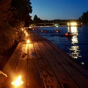  © Vansbrosimningen, The river in the dark with marshals on the bridge.