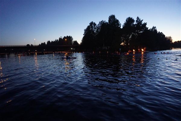  &copy; Vansbrosimningen, The river in darkness with shining marshals on the land on the other side of the water.