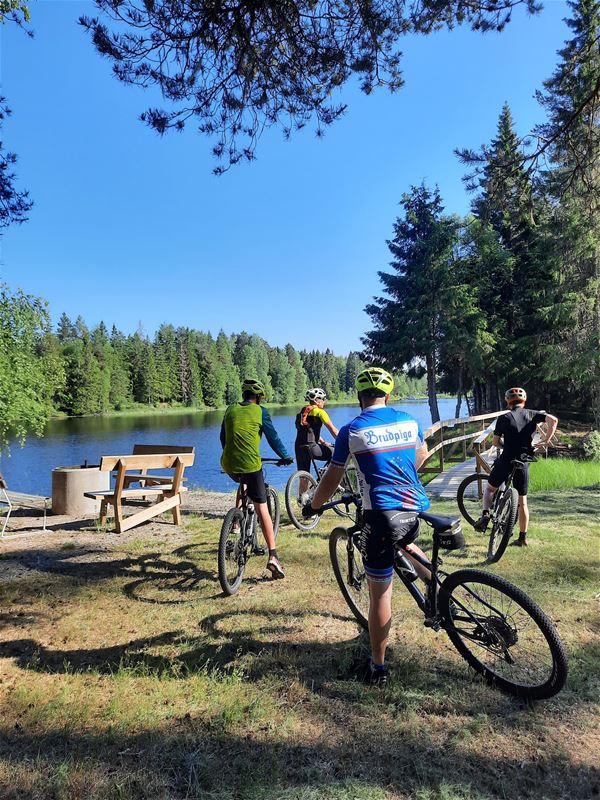 Some MTB riders take a break at a rest stop by the river.